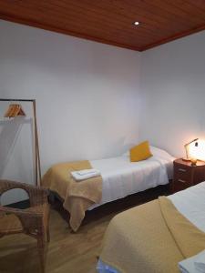 Santa RitaRefúgio das Pedreiras的一间卧室配有两张床和一张带台灯的桌子