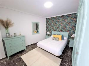 哈恩Piso-Loft COS Centro Jaén 2的卧室配有白色的床、梳妆台和西德西德克斯床