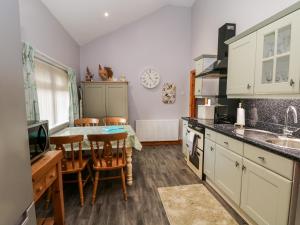 BroughWillow Lodge的厨房配有桌椅和水槽。