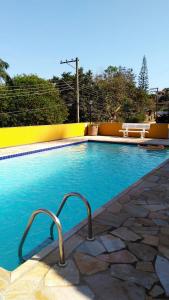 塞拉内格拉Condomínio Vila Paradiso的蓝色的海水和黄色的墙壁的游泳池