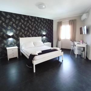 托瓦尼亚ALDIVA ROOMS的卧室配有白色的床、两张桌子和窗户。