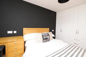 牛津Luxurious double bedroom, ensuite with free Wifi.的卧室配有白色的床和黑色墙壁