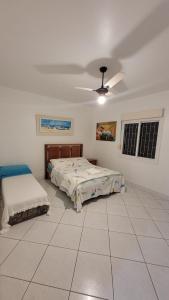 塞尔苏拉穆斯州长镇Casa de Praia em Palmas的一间卧室配有两张床和吊扇