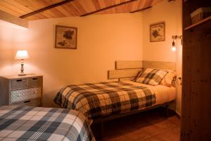 巴加Apartament Cadí- Moixeró的一间卧室配有两张床和一个带灯的床头柜