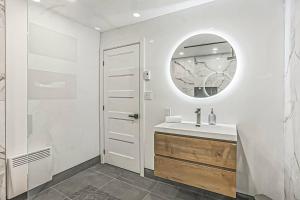 PrévostCheerful 4 bedroom home with inground heated pool的白色的浴室设有水槽和镜子