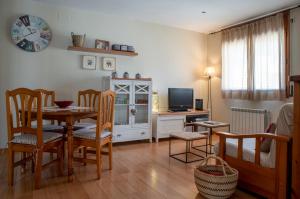 巴加Apartament Cadí- Moixeró的客厅设有餐桌和电视