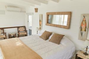何塞伊格纳西奥Laguna Garzón Lodge的卧室配有白色的床和镜子