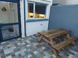 多尼戈尔AMY'S Place Charming 3 Bed House Donegal的木餐桌,坐在窗户外