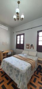 马瑙斯Casa 307的一间卧室配有一张大床和一个吊灯。