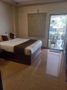 KurmannapalemBhimas Residency的一间卧室设有一张床和一个滑动玻璃门
