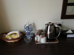 乔治市Goodhope Hotel Gurney, Penang的一张桌子,上面有咖啡壶和一篮子水