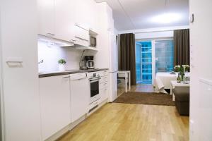 奥卢City center 1R studio with perfect view, parking的一间带白色橱柜的厨房和一间客厅