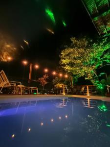 伊利亚贝拉SOL&MAR Suítes Ilhabela的夜晚带绿灯的游泳池