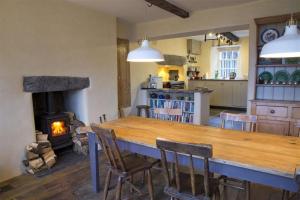 彭里斯Thomas Grove House的厨房配有大木桌和壁炉