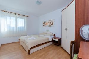 洛帕Apartments Marija P Lopar的白色的卧室设有床和窗户
