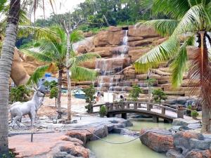 下龙湾Minh Hưng Motel的一座拥有瀑布、桥梁和棕榈树的动物园
