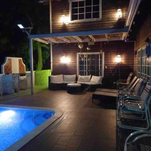 特拉Villa Brisa Marina的带沙发的庭院和夜间游泳池