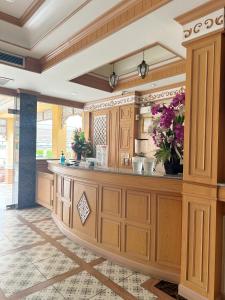 Nong Khaeโรงแรมกู๊ดเรสซิเดนซ์ - Good Residence的厨房配有木制橱柜和鲜花柜台。