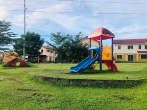 帕加迪安2 storey Camella Homes in Pagadian City的草地上带滑梯的游乐场