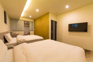 礁溪YY Elleys Home的酒店客房设有两张床和一台平面电视。