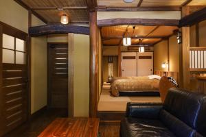 南小国町黑川温泉御宿酒店的一间卧室配有一张床和一张沙发