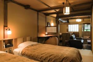南小国町黑川温泉御宿酒店的一间带两张床和一张书桌的卧室以及一间客房