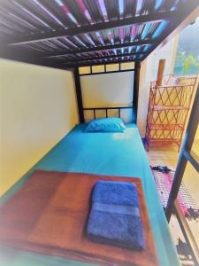 Phumĭ Chroŭy SvayThe Cocoon的一间卧室配有一张带蓝色床罩的床