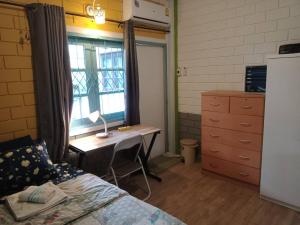 曼谷年轻美丽旅馆的一间卧室配有一张床、一张书桌和一个窗户。