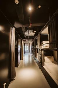新加坡7 Wonders Hostel @ Boat Quay的长长的走廊,房间内设有双层床