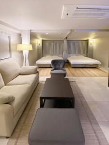 福冈precious days inn的带沙发和2张床的客厅