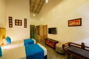 科伦坡Angam Villas Colombo的一间卧室配有一张床、一张沙发和一台电视。