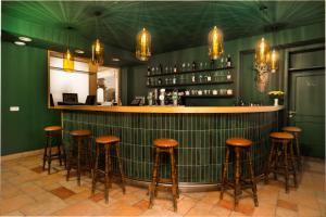 塞默灵施皮塔尔Hirschenhof的绿色墙壁上带棕色凳子的酒吧
