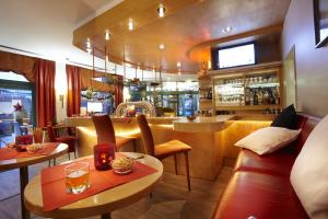 汉诺威汉诺威朗根哈根氛围酒店 - 郁金香酒店管理的一间带2张桌子的餐厅和一间酒吧