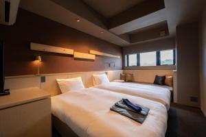 中津川市Onn nakatsugawa的酒店客房,配有两张带毛巾的床