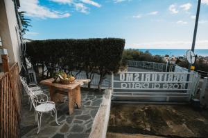 皮特拉利古Agriturismo Rose di Pietra的一个带桌椅的庭院和大海