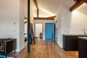 泰尔梅诺Eichhof Apartment Wacholder的开放式厨房以及带白色墙壁和木地板的客厅。