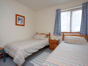 Clyst Saint MaryThe Stables的卧室设有两张单人床和窗户。