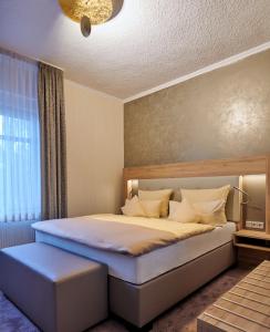 盖尔森基兴祖姆施万安姆比恩特酒店的一间卧室配有一张大床和蓝色凳子