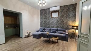 库塔伊西Nino's Cosy Apartment的客厅配有蓝色的沙发和桌子