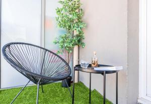 圣但尼CAOPEO - Top Hôte Paris - 8 personnes Balcon Parking的植物旁草上的一个椅子和桌子