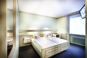 汉诺威普瑞米尔瑞卡拉斯汉诺威机场酒店的卧室配有一张大白色床和窗户