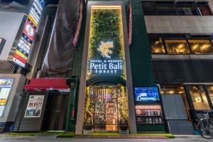 东京Petit Bali Forest Shinjuku Sanchōme的前面有标志的建筑