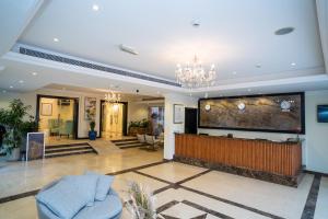 迪拜Royal Prestige Hotel的客厅配有大电视和吊灯。