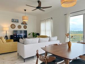 波德申BayView Suites Port Dickson By MAISON的客厅配有白色的沙发和桌子