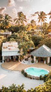 帕杰桑希巴白沙豪华别墅Spa度假村 - 罗莱夏朵精品酒店的享有带游泳池和棕榈树的度假村的景致