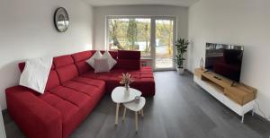 图特林根Unique geräumige 4 Zimmer Wohnung in Tuttlingen mit Netflix, Sauna und Fitness的客厅配有红色的沙发和桌子