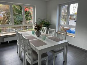 图特林根Unique geräumige 4 Zimmer Wohnung in Tuttlingen mit Netflix, Sauna und Fitness的白色的餐桌、椅子和窗户