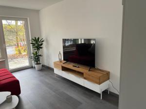 图特林根Unique geräumige 4 Zimmer Wohnung in Tuttlingen mit Netflix, Sauna und Fitness的客厅配有白色墙壁上的平面电视。