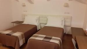 BuonabitacoloCountry House Poggio Alto的一间客房内配有两张床的房间