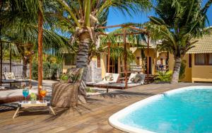 路易斯科雷亚Beekite Wind Village的一个带游泳池和棕榈树的度假村
